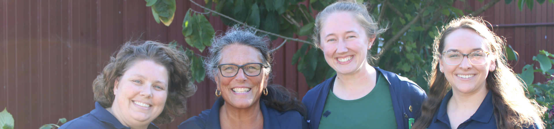  girl scout staff or volunteer wearing adult vest in woods smiling 